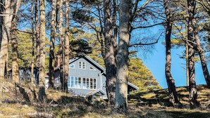 A cabin surrounded by tall trees, with a clear blue sky in the background. - 5 bedroom lovely home in Tanumshede (Tanumshede)
