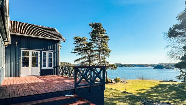 A wooden house with a deck overlooking a lake. - 5 bedroom lovely home in Tanumshede (Tanumshede)