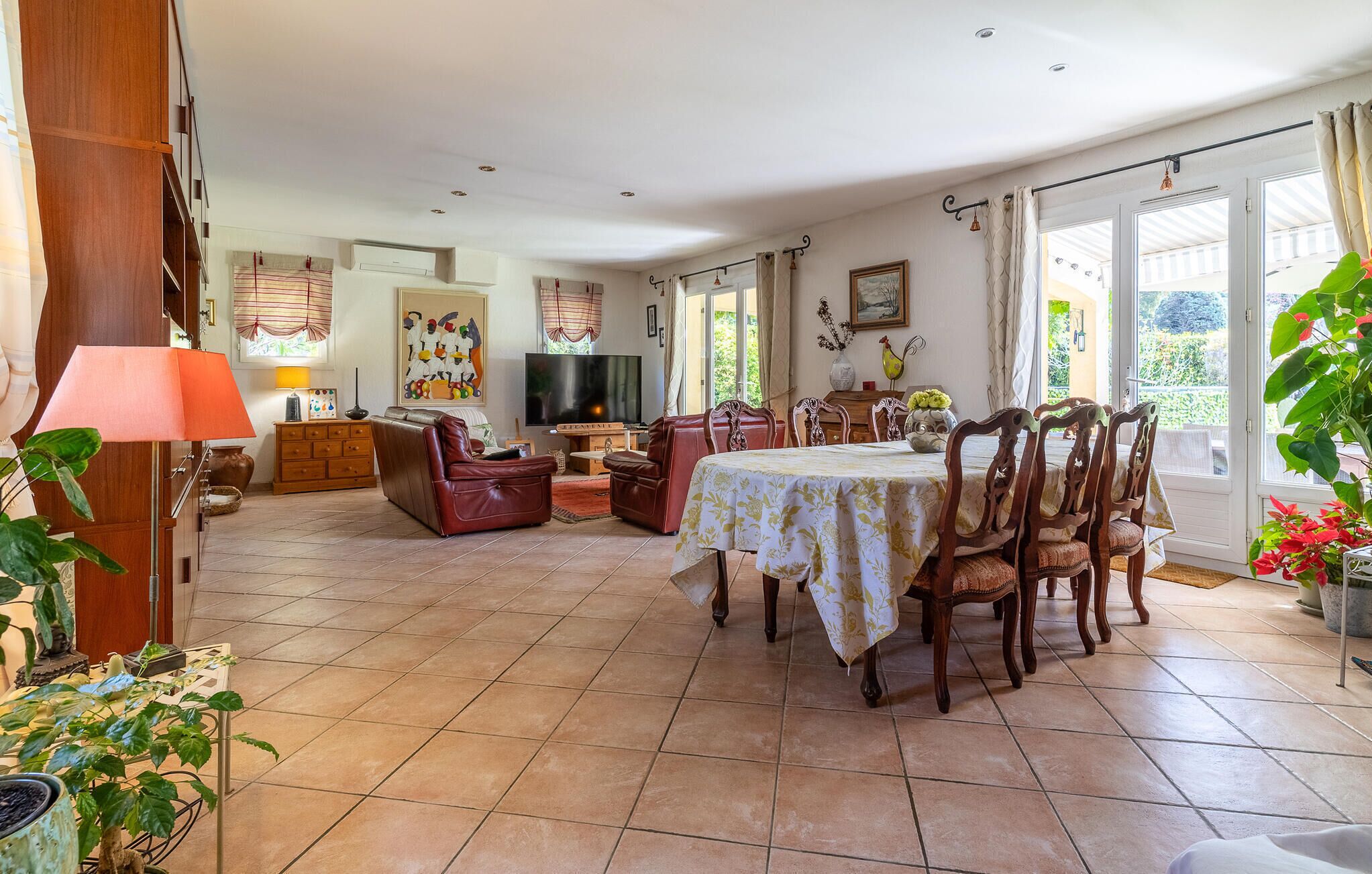 Una sala de estar amplia con comedor, televisor y chimenea.