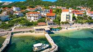 Un pueblo costero con edificios, una playa y un mar azul cristalino.