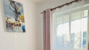 A neatly made bed with white and red linens, a red pillow, and a red blanket. - Cozy bed & breakfast in charming Mombasa County with WiFi (Mombasa County)