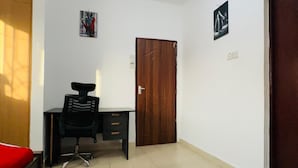 A room with a bed, a desk, a chair, a door, and a small rug. - Cozy bed & breakfast in charming Mombasa County with WiFi (Mombasa County)