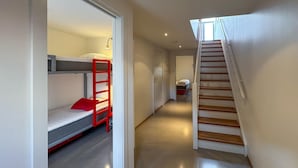 A corridor with bunk beds, a staircase, and a door leading to another room. - Cozy apartment in Søgne with house sea view (Søgne)