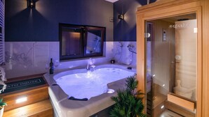 A modern spa room with a large hot tub, wooden flooring, and a wooden sauna. - Stunning home in Mrkopalj with sauna (Mrkopalj)