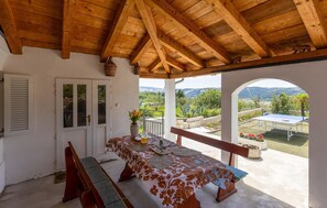 Enjoy al fresco dining in this serene outdoor space with a view of lush greenery.