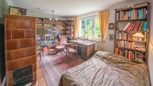 Una habitación acogedora con una amplia estantería, un escritorio y una cama confortable.