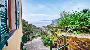 Eine schmale Steintreppe führt zu einem Balkon mit Blick auf die Küste.