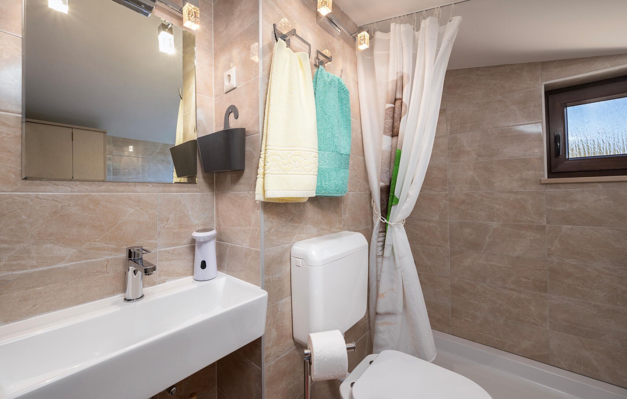 Ein modernes Badezimmer mit Waschbecken, Toilette und Dusche.