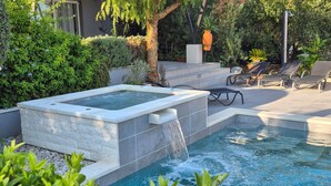 A spa area with a hot tub, lounge chairs, and a waterfall feature. - Beautiful home in Kastel Stari (Kastel Stari)
