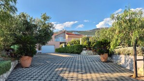 A modern two-story house with a paved driveway leading to a garage. - Beautiful home in Kastel Stari (Kastel Stari)