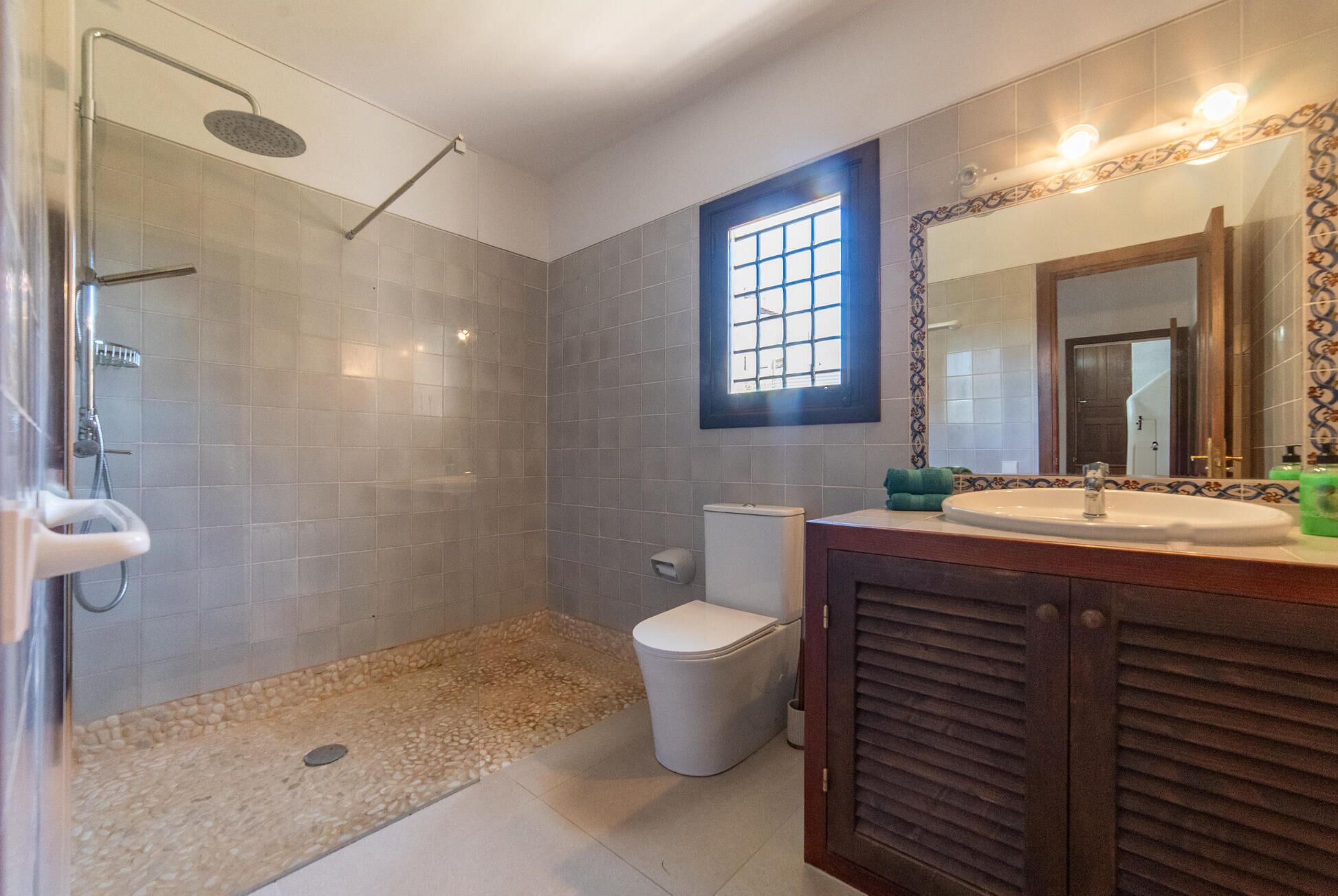 A bathroom with a shower, toilet, and sink.