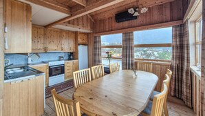 Ein Holzinterieur mit einer Küche, einem Esstisch und Stühlen.