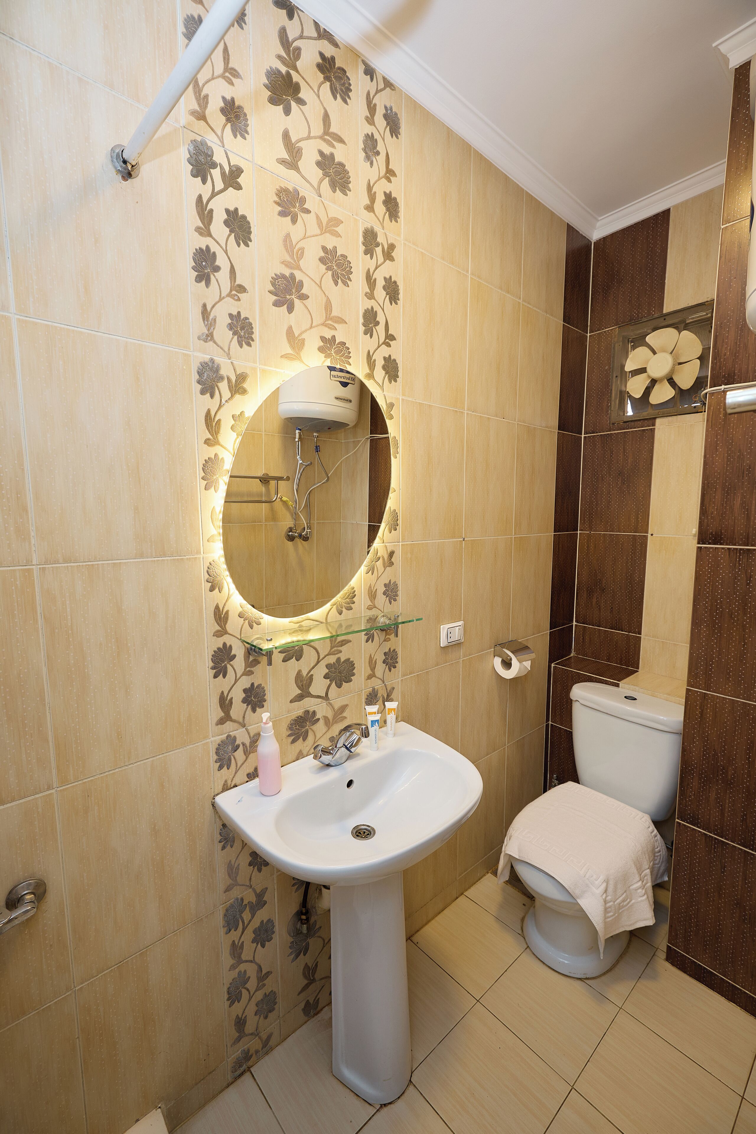 A bathroom with a sink, mirror, toilet, and shower.