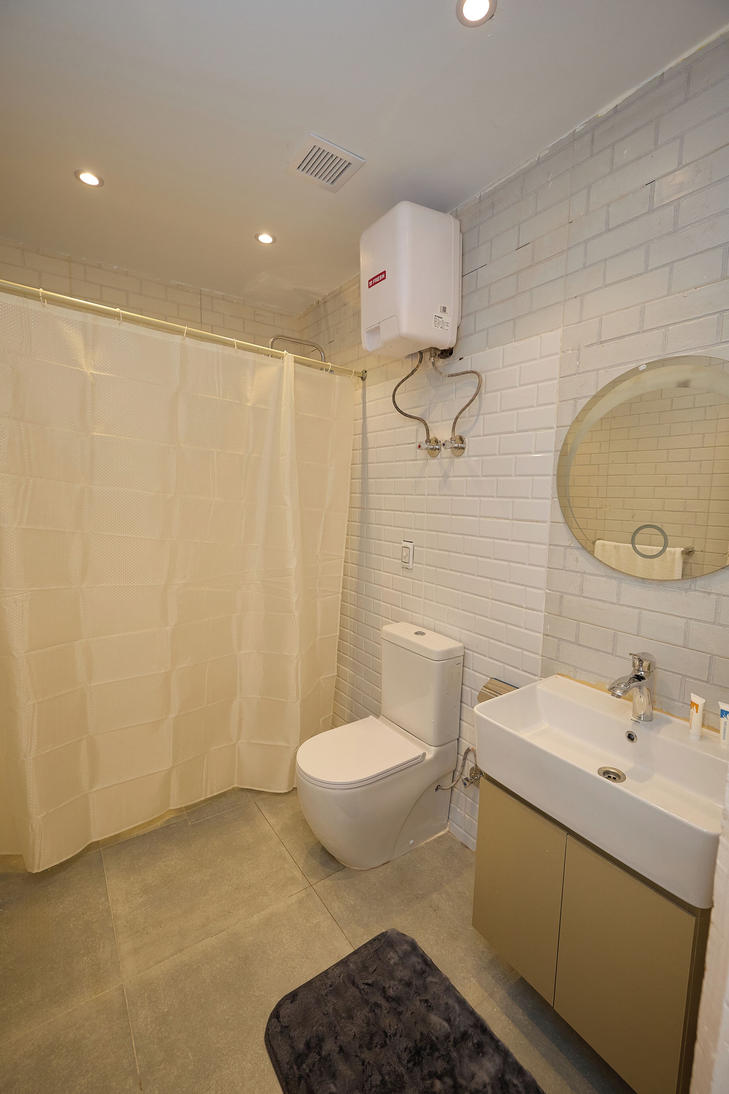 A bathroom with a toilet, sink, mirror, and shower curtain.