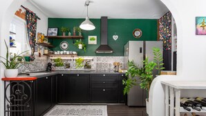 A kitchen with dark cabinets, a green accent wall, and various plants. - 2 bedroom awesome apartment in Drazice (Drazice)