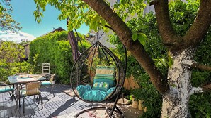 A patio with a hanging chair, a table, and chairs. - 2 bedroom awesome apartment in Drazice (Drazice)