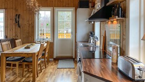 A modern kitchen with wooden cabinetry, a stainless steel sink, and a built-in toaster.