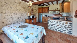 Una cocina rústica con armarios de madera, una pared de piedra y un salpicadero de azulejos.