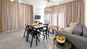 Una sala moderna con comedor, que incluye un sofá, una mesa de comedor, sillas y un frutero.