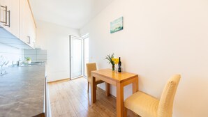 Eine moderne Küche mit Essbereich, einem Holztisch und einem Stuhl.
