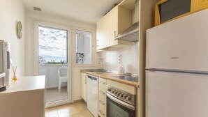 Una cocina compacta con refrigerador, horno y lavaplatos.