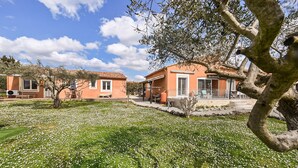 A property with two buildings, a patio area, and a garden with white flowers. - Comfortable, pittoresques (Combas)