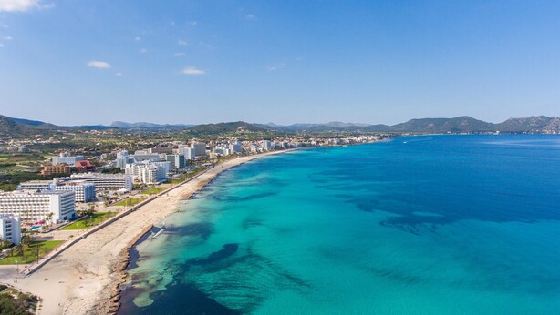 A coastal cityscape with a long beachfront, high-rise hotels, and a clear blue sea. - Nice home in Son Servera (Son Servera)