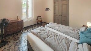 Ein Schlafzimmer mit Bett, Kommode, Stuhl und Kleiderschrank.