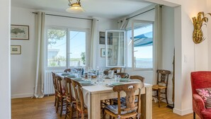 A dining area with a wooden table set for six, surrounded by wooden chairs. - Awesome home in Saint-Trojan-les-Bains (Saint-Trojan-les-Bains)