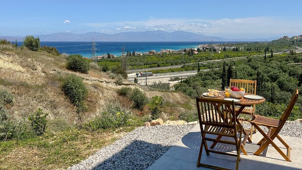Una mesa con vistas a un pueblo costero y montañas al fondo.