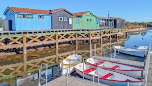 A waterfront property with colorful wooden buildings, a dock, and boats.