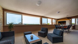 A spacious balcony with wicker furniture, a glass-top table, and a view of the sea. - Awesome apartment in Skabrnja (Skabrnja)