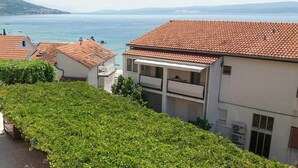 A coastal residential area with terracotta-tiled buildings, a balcony, and a view of the sea. - Amazing apartment in Duce with house sea view (Duce)