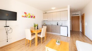 A compact living space with a dining area, a kitchen, and a TV mounted on the wall. - Amazing apartment in Duce with house sea view (Duce)