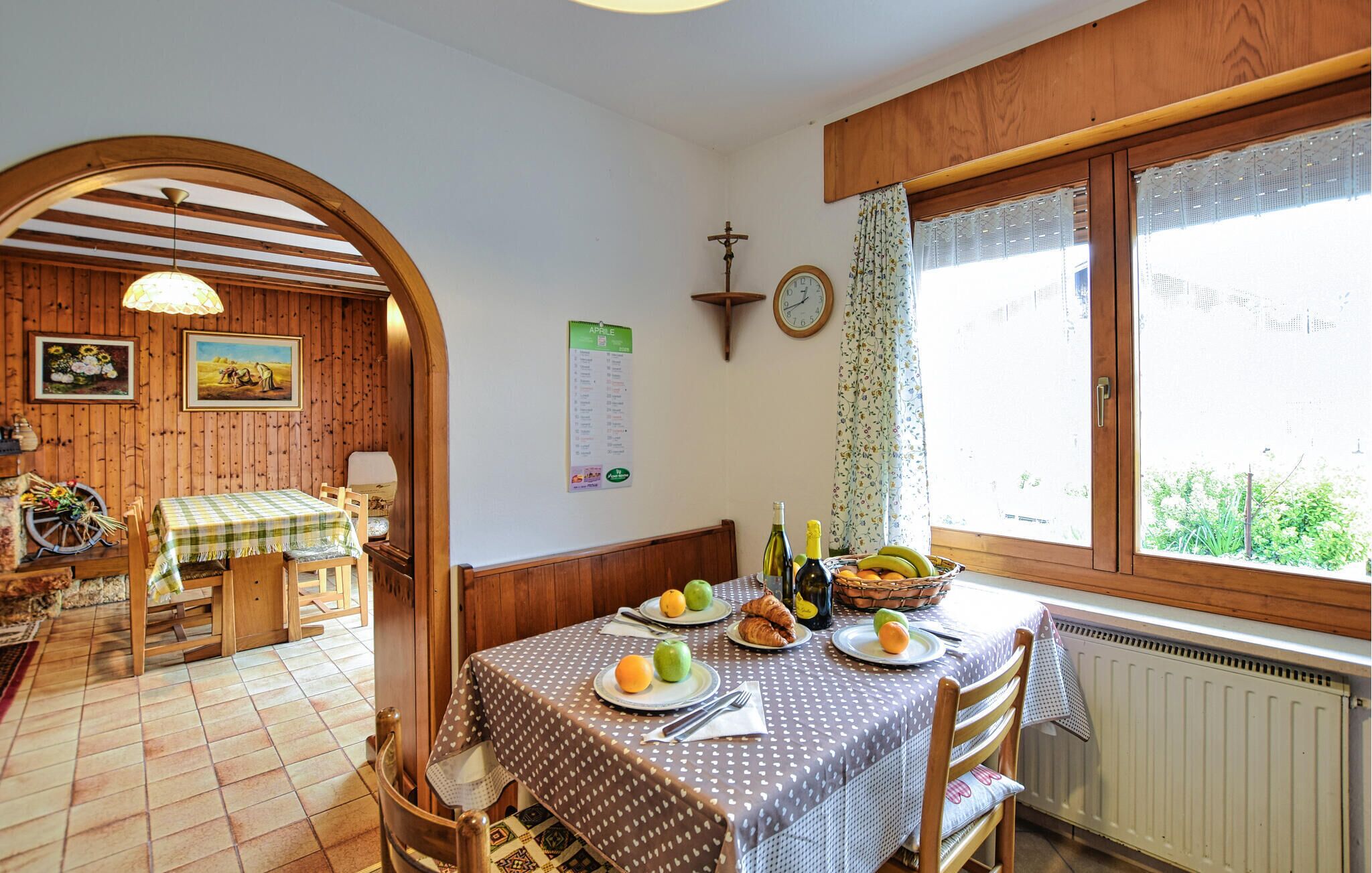 Uma área de refeições com mesa posta para dois, decoração em madeira e janela com vista.