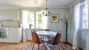 A kitchen with wooden flooring, white cabinets, a dining table with chairs, and a chandelier. - 2 bEdroom gorgeous home in Ed (Ed)