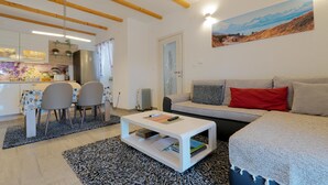 Una sala de estar moderna con sofá, mesa de centro y comedor.
