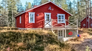 A red cabin with a balcony, surrounded by forest. - Nice apartment in Sälen with sauna (Sälen)