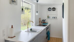 A modern kitchen with a large window, a sink, and a countertop. - 2 bedroom lovely home in Dannemare (Dannemare)