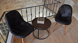 A room with two black upholstered chairs and a small round table with a sign. - Room-room With the City and sea View (Split)