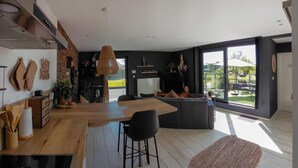 A modern kitchen with a large island, a dining area with a table and chairs, and a large sliding glass door leading to an outdoor patio. - 1 bedroom lovely apartment in Visé (Visé)