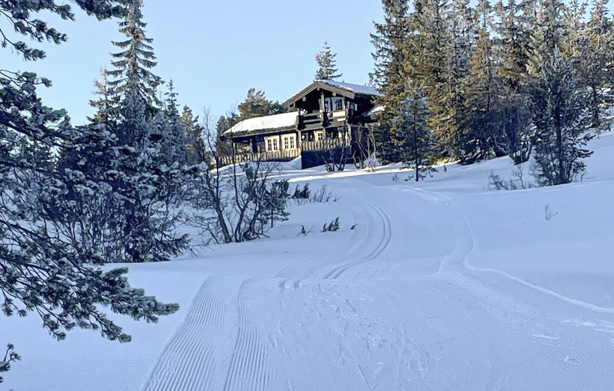 A snow-covered ski slope with a lodge in the background.