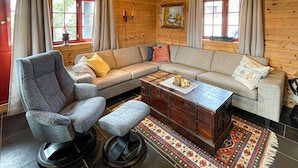 A cozy living room with a grey sofa, a wooden coffee table, and a patterned rug.