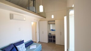 A modern room with a blue sofa, white walls, and a glass door leading to a balcony. - Amazing home in Castellabate with WiFi (Castellabate)