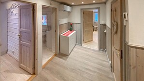 A hallway with wooden flooring and doors leading to different rooms.