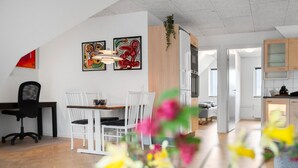 A modern kitchen with white cabinets, a wooden countertop, and a hanging plant. - Cozy apartment in Varde with WiFi (Varde)