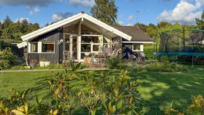 A modern house with a large patio, a trampoline, and a well-maintained garden. - Cozy home in Dronningmølle with WiFi (Dronningmølle)