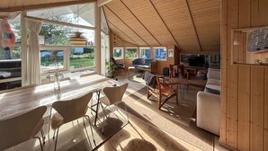 A cozy cabin interior with a dining area, seating, and a TV. - Cozy home in Dronningmølle with WiFi (Dronningmølle)