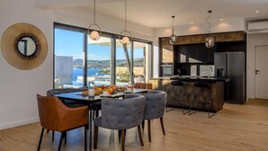 A modern kitchen with a large island, a dining area with a view, and a bar area.