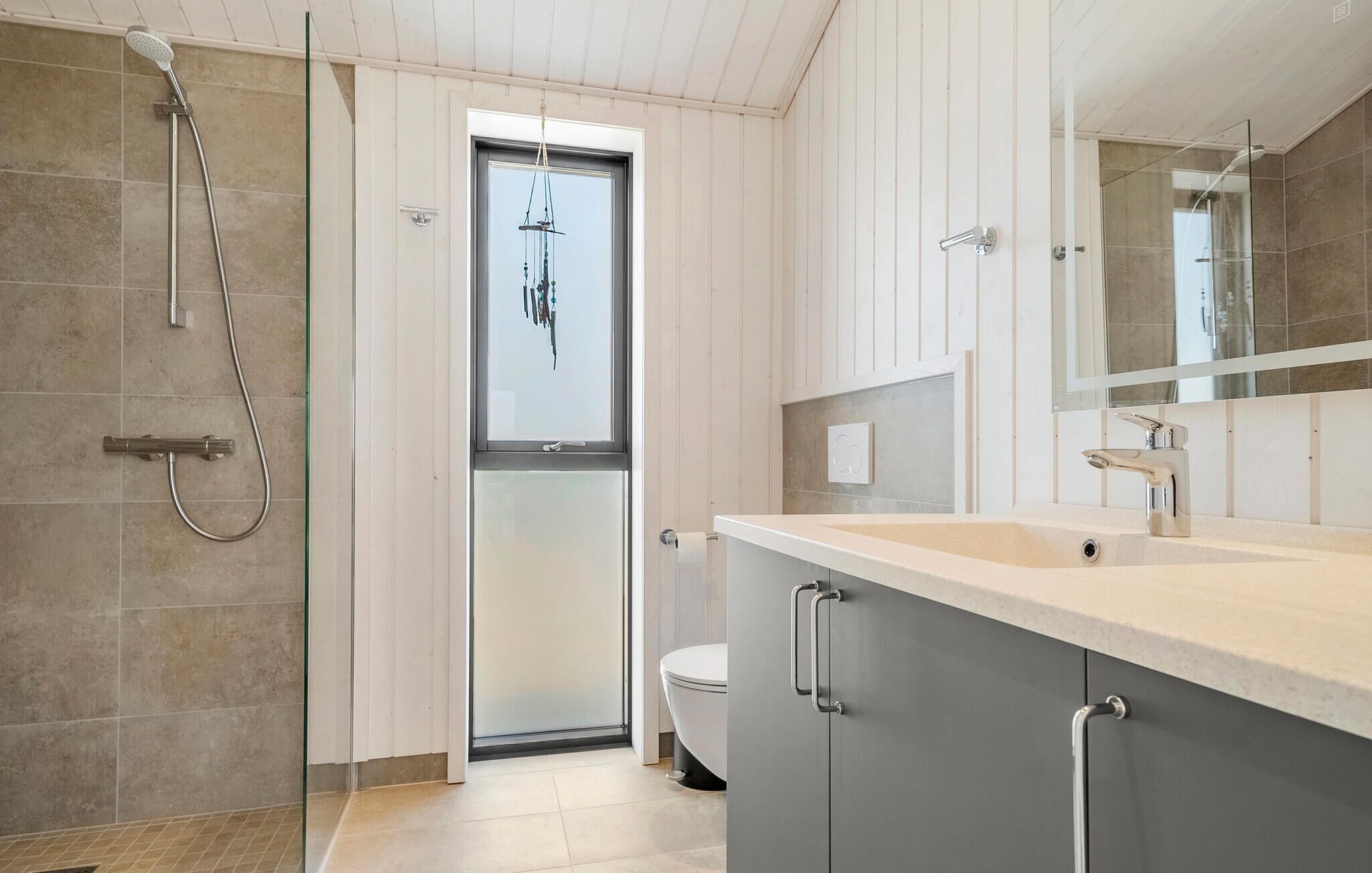 Ein modernes Badezimmer mit Dusche, Toilette und Waschbecken.